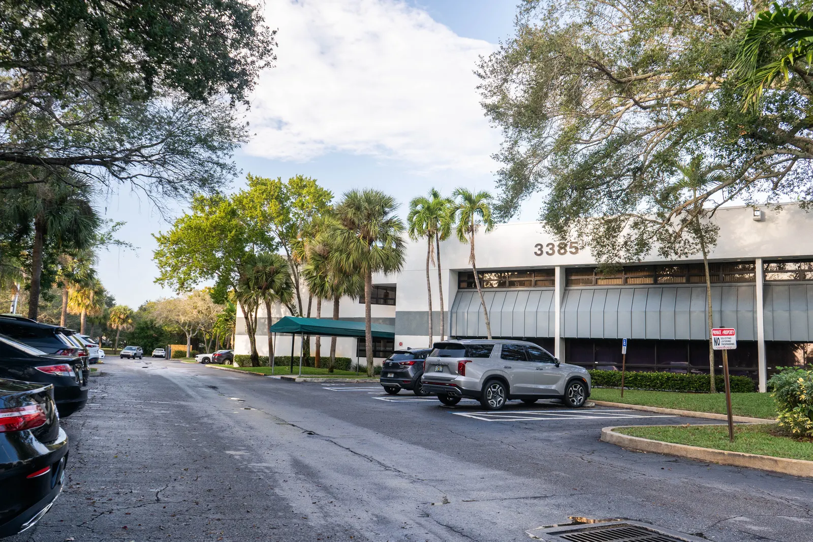 Parking lot with cars in front of Smile Associate's dental office in Palm Beach Gardens.