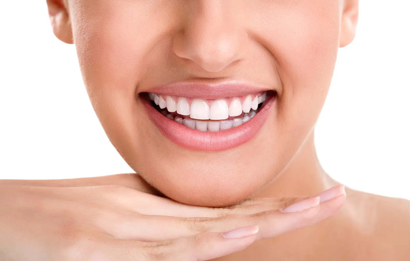 Close-up of a woman's smile with white teeth resting her chin on her hand against a white background.