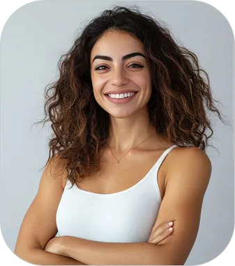 Smiling woman with curly hair wearing white tank top, arms crossed against light gray background.